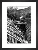 Maasai woman constructing a house