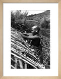 Maasai woman constructing a house