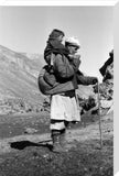 Tajik man carrying a boy on his back