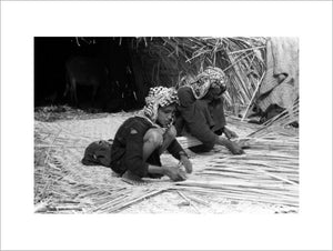 Suaid man and boy weaving mats