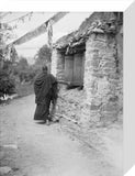Monk turning prayer wheel on linghkor